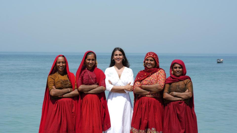 Okhai Artisans in Mithapur standing with crossed arms in front of the beautiful blue green waters of the Gulf of Kutch